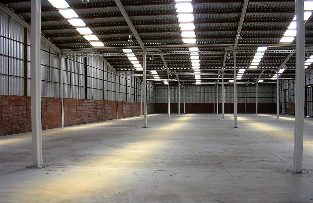 Interior del proyecto industrial Atenea I con estructura metálica y lucarnas.